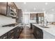 Modern kitchen featuring stainless steel appliances, dark cabinets, and bright countertop space at 17163 Desert Wine Trl, Parker, CO 80134