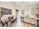 Bright modern kitchen highlighting white cabinets, a glass dining table, and pendant lighting at 6102 S Owens Ct, Littleton, CO 80127
