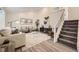 Bright open-plan living space with staircase and modern furnishings under recessed lights at 6102 S Owens Ct, Littleton, CO 80127