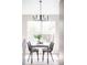 Well-lit dining area featuring a modern chandelier, a table set for four, and a window at 1566 S Richfield Way, Aurora, CO 80017