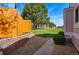 A gravel walkway leads to a grass backyard, enclosed by a wooden fence and brick retaining wall at 7996 Chase Cir # 5, Arvada, CO 80003