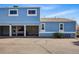 A light-blue townhome with covered parking features a spacious, paved driveway at 7996 Chase Cir # 5, Arvada, CO 80003
