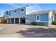 A light-blue townhome features covered parking and is surrounded by a spacious paved driveway at 7996 Chase Cir # 5, Arvada, CO 80003