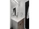 Compact bathroom featuring a vanity with wood cabinets, a sink, and a mirrored wall at 1930 Hooker St # 3, Denver, CO 80204