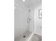 Modern glass walk-in shower featuring white tile walls and gray hexagonal tile flooring at 1930 Hooker St # 3, Denver, CO 80204