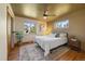 Cozy bedroom with hardwood floors, ceiling fan, natural light, and a queen-sized bed dressed in white linens at 3540 Vrain St, Denver, CO 80212