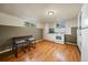 Functional kitchen with white appliances, wood floors, and a small dining table set against panelled walls at 3540 Vrain St, Denver, CO 80212