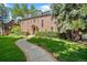 Grand brick home with manicured lawn and walkway at 869 Vine St, Denver, CO 80206