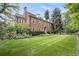Brick home with a large lawn and mature trees at 869 Vine St, Denver, CO 80206