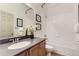 Well-lit bathroom with a sink, framed mirror, decorative pictures, and shower-tub combo at 1562 Suncrest Rd, Castle Rock, CO 80104