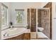 Luxurious bathroom with a soaking tub, tiled shower, and large window offering natural light at 1562 Suncrest Rd, Castle Rock, CO 80104