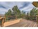 Expansive deck with decorative railings, providing a tranquil outdoor space surrounded by lush trees at 1562 Suncrest Rd, Castle Rock, CO 80104