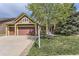 Charming home with a well-manicured lawn, stone accents, and a spacious three car garage at 1562 Suncrest Rd, Castle Rock, CO 80104
