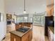 Open concept kitchen with center cooktop island, granite countertops, and views of the living room fireplace at 1562 Suncrest Rd, Castle Rock, CO 80104