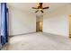 Large main bedroom featuring a ceiling fan, neutral carpet, and an open doorway to the bathroom at 1562 Suncrest Rd, Castle Rock, CO 80104