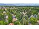 Aerial view shows neighborhood with mature trees and mountain views at 6371 Brooks Dr, Arvada, CO 80004