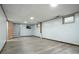 Unfinished basement with neutral vinyl flooring, light blue walls, and access to storage shelving at 6371 Brooks Dr, Arvada, CO 80004