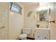 Bathroom with standard toilet, sink and vanity, and tiled walls with decorative leaf at 6371 Brooks Dr, Arvada, CO 80004
