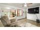 Open concept living space with hardwood flooring, ceiling fan, and a seamless transition to the adjacent kitchen and dining area at 6371 Brooks Dr, Arvada, CO 80004