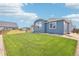 The home's private backyard is a verdant expanse of lush green grass with a fence for added security at 15987 E 115Th Pl, Commerce City, CO 80022