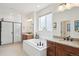 Bright bathroom boasts double vanities, a soaking tub, and walk-in glass shower at 15987 E 115Th Pl, Commerce City, CO 80022