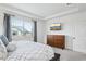 Well-lit bedroom features a large window and sleek dresser with light gray walls at 15987 E 115Th Pl, Commerce City, CO 80022