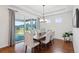 Cozy dining room with hardwood floors, a modern chandelier, and sliding door access to the backyard at 15987 E 115Th Pl, Commerce City, CO 80022