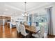 Elegant dining room with hardwood floors, a modern chandelier, and sliding door access to the backyard at 15987 E 115Th Pl, Commerce City, CO 80022