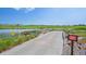 Scenic view of a golf course with a water hazard, green grass, and houses in the distance at 15987 E 115Th Pl, Commerce City, CO 80022