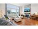 Bright living room with stone fireplace, large windows, and hardwood floors at 15987 E 115Th Pl, Commerce City, CO 80022