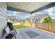 Covered patio with a decorative rug and chairs overlooking a fenced backyard with green grass at 15987 E 115Th Pl, Commerce City, CO 80022