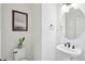 Charming powder room with pedestal sink, decorative mirror, and stylish wall art at 15987 E 115Th Pl, Commerce City, CO 80022
