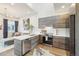Open kitchen with modern appliances, a breakfast bar, and adjacent living area at 3550 W 63Rd Ave, Denver, CO 80221