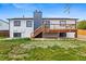 Back exterior of the house with a wooden deck and a small grassy area at 2484 E 101St Ct, Thornton, CO 80229
