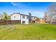 Spacious backyard featuring a well-maintained lawn, a wooden fence, and a deck accessible from the house at 2484 E 101St Ct, Thornton, CO 80229