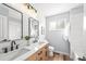 Modern bathroom with dual sinks, wood cabinets, shiplap walls, and a separate toilet and shower area at 2484 E 101St Ct, Thornton, CO 80229