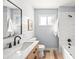 Bright bathroom featuring shiplap walls, stylish fixtures, and a shower-tub combination with white marble tiles at 2484 E 101St Ct, Thornton, CO 80229