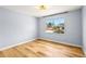 Bright bedroom featuring hardwood floors, modern lighting, and a large window with neighborhood views at 2484 E 101St Ct, Thornton, CO 80229