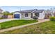 Landscaped front yard featuring a modern ranch style home with a vibrant lawn and gravel walkway at 2484 E 101St Ct, Thornton, CO 80229
