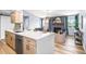 Modern kitchen open to living room with stainless steel appliances and quartz countertops, perfect for entertaining at 2484 E 101St Ct, Thornton, CO 80229
