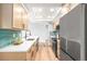 Well-lit kitchen features a long island, stainless steel refrigerator, and hardwood flooring at 2484 E 101St Ct, Thornton, CO 80229