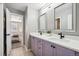 Stylish bathroom featuring double vanity, modern fixtures, and an open doorway to a bedroom at 6269 S Coventry E Ln, Littleton, CO 80123