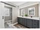 Stylish bathroom with gray vanity, double sinks, modern mirrors, and a sliding barn door at 6269 S Coventry E Ln, Littleton, CO 80123