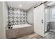 Elegant bathroom featuring a soaking tub with decorative tile and a glass-enclosed shower at 6269 S Coventry E Ln, Littleton, CO 80123