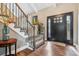 Inviting foyer with hardwood floors, staircase with iron railings, and stylish front door at 6269 S Coventry E Ln, Littleton, CO 80123