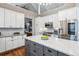 Open kitchen with gray island, stainless steel appliances and white cabinets at 6269 S Coventry E Ln, Littleton, CO 80123