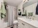 Bathroom featuring a white vanity, patterned shower curtain and coordinated décor at 6194 E Briarwood Cir, Centennial, CO 80112