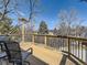 View of wood deck with metal chairs and black metal railing overlooking lush trees at 6194 E Briarwood Cir, Centennial, CO 80112