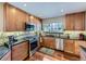 Cozy kitchen featuring wood cabinets, stainless steel appliances, granite countertops, and beautiful backsplash at 6194 E Briarwood Cir, Centennial, CO 80112