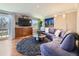 Inviting living room with curved sofa, large TV, and plenty of natural light at 6194 E Briarwood Cir, Centennial, CO 80112